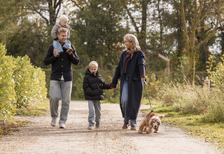 Famille en promenade avec un chien sur un chemin près de Holiday villa Amalia 6 + sauna, moment paisible.
