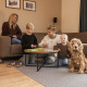 Gezin geniet samen met hun hond van een spel in de knusse woonkamer van een lodge.
