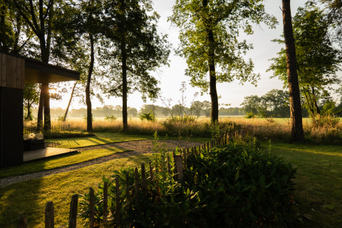 Sonnenuntergang bei Vakantievilla Boslodge 2 mit Sauna im Hofparken Wiltershaar, Niederlande, mit Wald und Wiese.