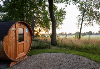 Fasssauna bei Vakantievilla Boslodge 2 met sauna im Hofparken Wiltershaar, Niederlande, bei Sonnenaufgang.