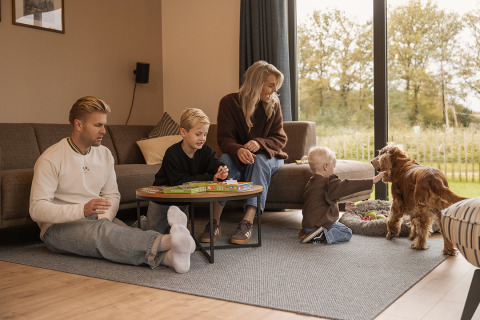 Familie genießt entspannte Zeit mit Kindern und Hund in der Ferienvilla bei Hofparken Wiltershaar.