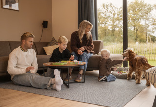 Famiglia si gode un momento con bambini e cane in una villa vacanze a Hofparken Wiltershaar, Paesi Bassi.
