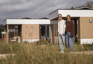 Dos personas de la mano frente a la villa Amalia con sauna y jacuzzi en Hofparken Wiltershaar, Países Bajos.