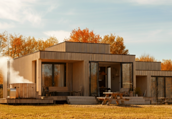 Moderne lodge Villa Hottub bij Resort de Parel in Nederland, met terras, herfstbomen en een buiten-hottub.