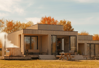 Moderne lodge Villa Hottub bij Resort de Parel in Nederland, met terras, herfstbomen en een buiten-hottub.