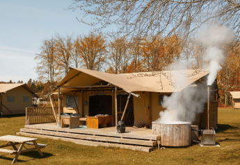 Safari glamping telt La Gran Vida ved Resort de Parel, Holland, med udendørs spabad og træterrasse.