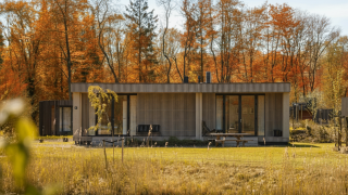Lodge Hottub moderne au Resort de Parel aux Pays-Bas, entouré d’arbres aux couleurs d’automne.