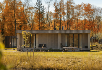 Lodge Hottub moderne au Resort de Parel aux Pays-Bas, entouré d’arbres aux couleurs d’automne.