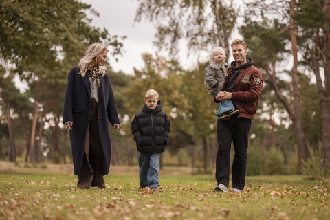 Une famille se promène ensemble sur la pelouse près de la Holiday villa Amalia 6, entourée d’arbres verts.
