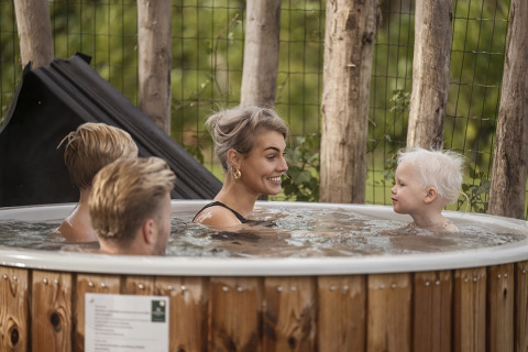 Famille profitant du bain à remous à la villa Amalia 4 chez Hofparken De Bergvennen aux Pays-Bas.