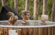Famiglia si rilassa nella vasca idromassaggio a Vacation villa Amalia 4, Hofparken De Bergvennen, Paesi Bassi.