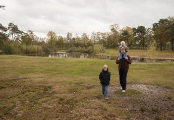 Familie spaziert im Grünen am See bei der Vacation villa Amalia 4 mit Whirlpool, Hofparken De Bergvennen.