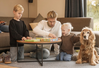 Familie speelt bordspel met kinderen en hond in de woonkamer van Vacation villa Amalia 4 in Nederland.