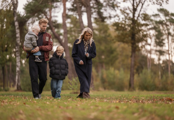 Eine Familie spaziert gemeinsam durch einen Waldpark bei Vacation villa Amalia 4, Hofparken De Bergvennen, Niederlande.