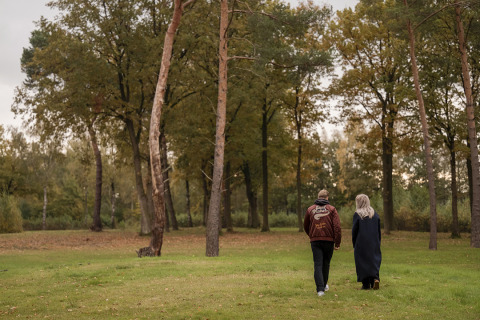 Dos personas caminan por un parque verde junto a Holiday villa Amalia 2 en Hofparken De Bergvennen, Países Bajos.
