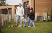 Una familia con dos niños y un perro disfruta afuera en una cabaña en Hofparken De Bergvennen, Países Bajos.