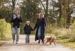 Familie går med hund på en natursti ved Vakantievilla Amalia 4 i Hofparken De Bergvennen, Holland.