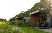 Modern holiday lodges at Holiday Villa Amalia 2, Hofparken Wiltershaar, Netherlands, surrounded by greenery.