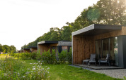 Lodges modernes à Holiday villa Amalia 2, Hofparken Wiltershaar, Pays-Bas, entourés de verdure.