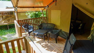 Houten terras met stoelen en tafel aan een Safaritent 4 personen incl. toilet, gezellige buitenplek.