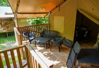 Überdachte Holzveranda mit Gartenmöbeln vor einem Safarizelt 4 Personen inkl. Toilette.