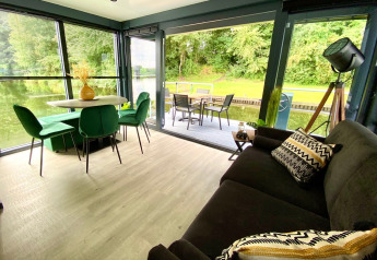 Moderne woonkamer en eetruimte op Houseboat Marina Mookerplas met waterzicht en terras in Nederland.