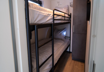 Smalle slaapkamer met een modern stapelbed op Houseboat Marina Mookerplas in Nederland.