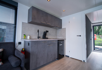 Moderne keukenhoek in een lodge van Houseboat Marina Mookerplas in Nederland met grijze kasten en minibar.