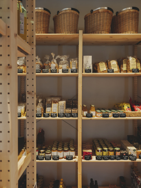 Étagères en bois avec paniers, snacks et pots de miel dans une boutique à Wecamp Pedraforca, Catalogne.