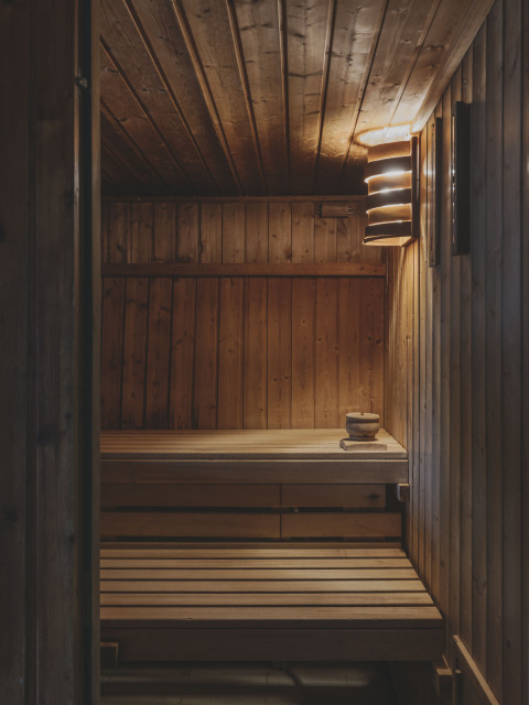 Houten sauna met banken en sfeervolle verlichting bij Wecamp Pedraforca vakantiepark in Catalonië, Spanje.