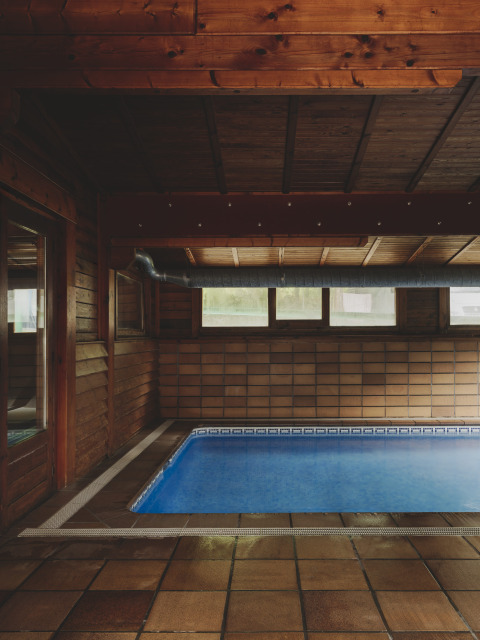 Overdekt zwembad met houten wanden en plafond bij Wecamp Pedraforca vakantiepark in Catalonië, Spanje.