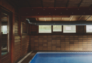 Overdekt zwembad met houten wanden en plafond bij Wecamp Pedraforca vakantiepark in Catalonië, Spanje.
