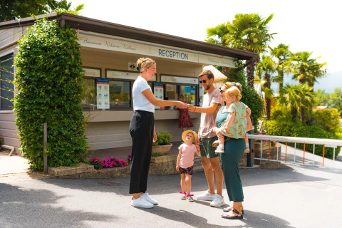 Familie tjekker ind ved receptionen på Weekend Glamping Resort, et feriepark i Lombardiet, Italien.