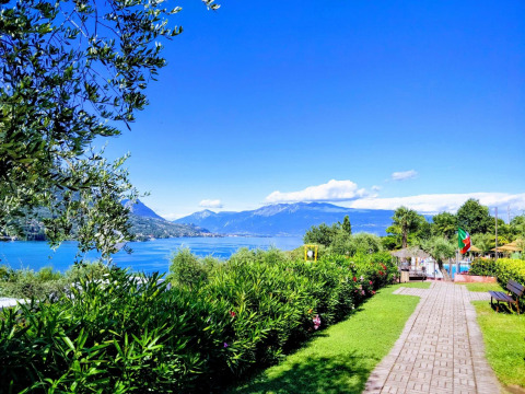 Vista sul Lago di Garda dal Weekend Glamping Resort in Lombardia, Italia, con montagne e natura rigogliosa.