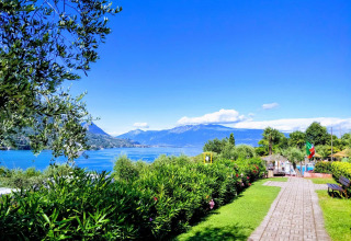 Blick auf den Gardasee vom Weekend Glamping Resort in der Lombardei, Italien, mit Bergen und viel Grün.