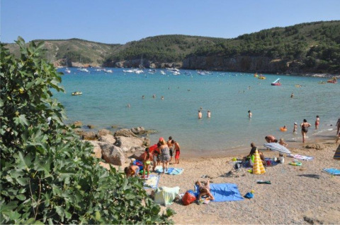 Holidaymakers enjoy the beach and swim in the sea at Wecamp L'Escala Punta Mila holiday park, Catalonia, Spain.
