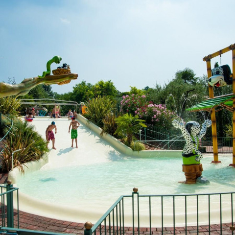 Børn leger på en vandrutsjebane i Weekend Glamping Resort i Lombardiet, Italien, omgivet af sjove figurer.