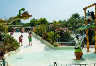 Kinder spielen auf einer Wasserrutsche im Weekend Glamping Resort in der Lombardei, Italien, mit Wasserspielen.