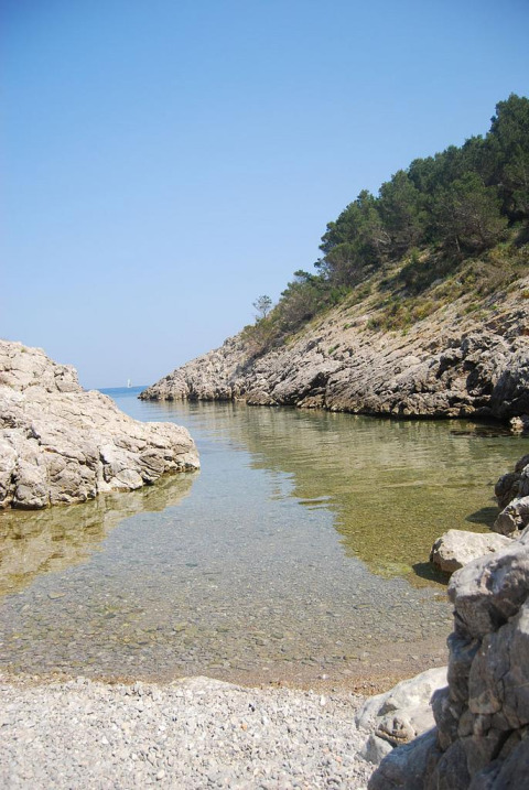 Schilderachtige rotsachtige baai met helder water bij Wecamp L’Escala Punta Mila, een vakantiepark in Catalonië.