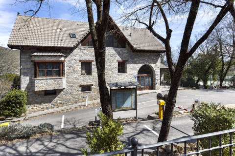 Steingebäude mit Schrägdach an der Wecamp Pirineos Ferienanlage in Aragonien, Spanien, umgeben von Bäumen.