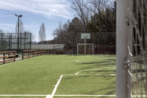Mehrzwecksportplatz mit Basketballkorb und Fußballtor im Wecamp Pirineos, Aragón, Spanien.