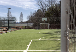 Multi-use sports field with soccer goal and basketball hoop at Wecamp Pirineos holiday park, Aragón, Spain.