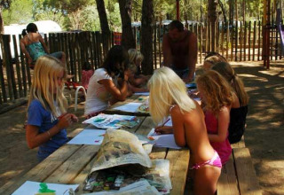 Niños participan en una actividad artística al aire libre en Wecamp L'Escala Punta Mila, Cataluña, España.