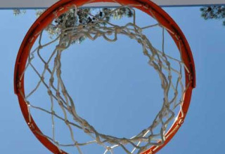 Basketballkorb mit Netz von unten betrachtet vor blauem Himmel im Wecamp L'Escala Punta Mila, Katalonien, Spanien.