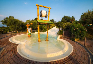 Children's splash pool with themed figures and a water slide at Weekend Glamping Resort in Lombardy, Italy.