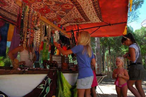Marktkraam op Wecamp L'Escala Punta Mila vakantiepark in Catalonië, Spanje, met mensen die sieraden bekijken.
