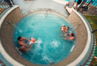 Ovenfra billede af familier, der nyder en rund swimmingpool på Weekend Glamping Resort i Lombardiet, Italien.