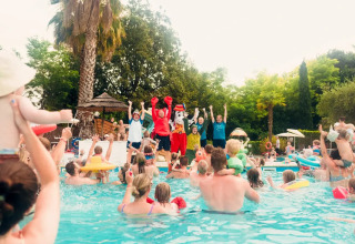 Bambini e famiglie festeggiano in piscina con animatori al Weekend Glamping Resort in Lombardia, Italia.