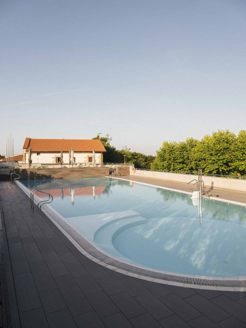 Outdoor swimming pool at Wecamp San Sebastián holiday park in Basque Country, Spain, under clear skies.