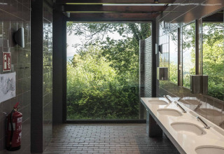 Modernes Badezimmer mit großen Fenstern und Blick auf die Natur im Wecamp San Sebastián, Baskenland, Spanien.